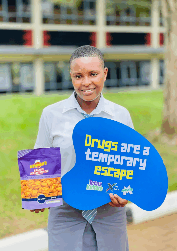 Student holding a bag of Newman's salted maize snack and a sign that reads, "Drugs are a temporary escape."