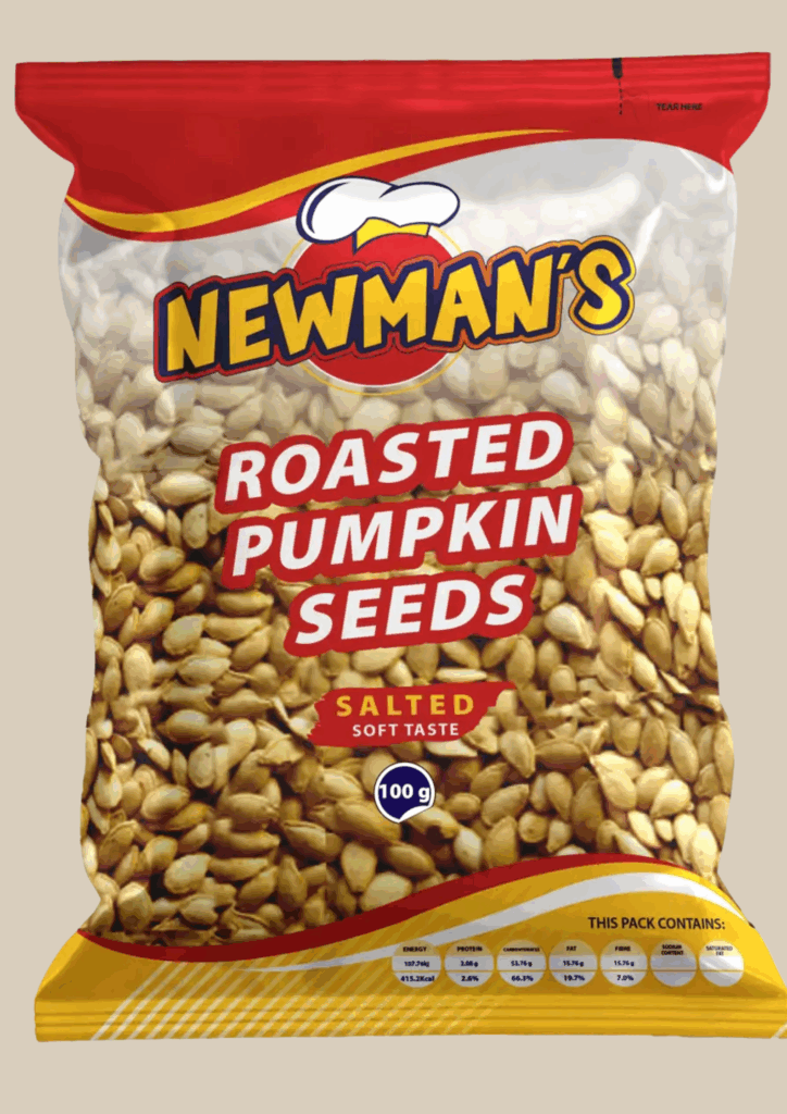 A clear, close-up image of a 100g bag of Newman's Roasted Pumpkin Seeds. The transparent bag is filled with golden-brown seeds, featuring a red and yellow logo and a label that reads "ROASTED PUMPKIN SEEDS" and "SALTED SOFT TASTE.