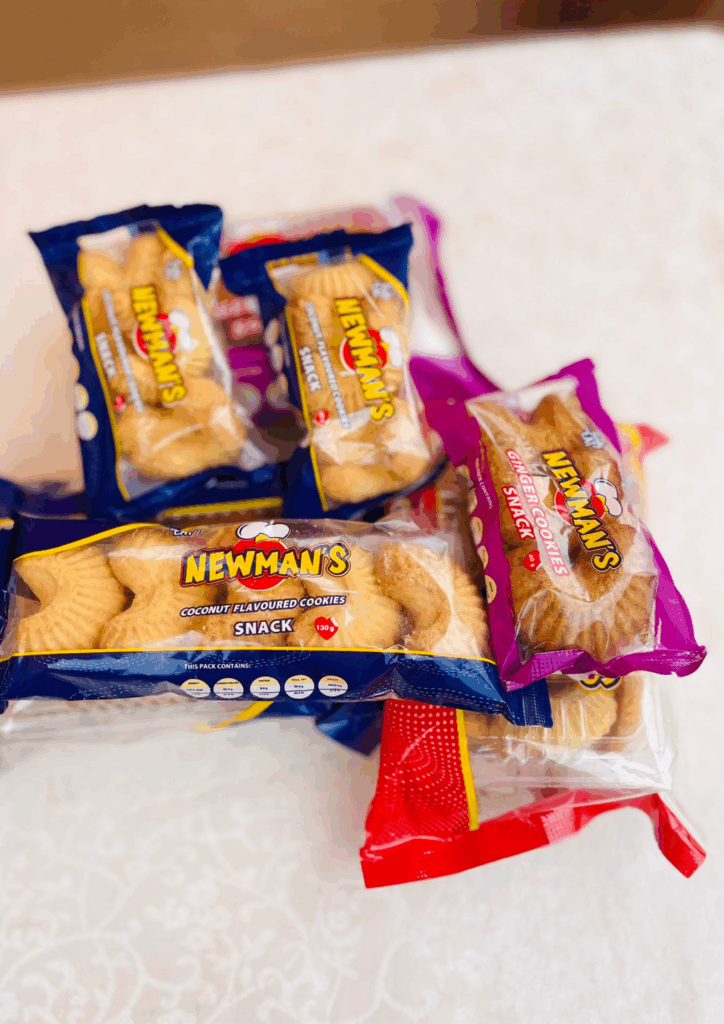 Close-up photo of various Newman's cookie packages stacked, featuring the Ginger and Coconut flavors.