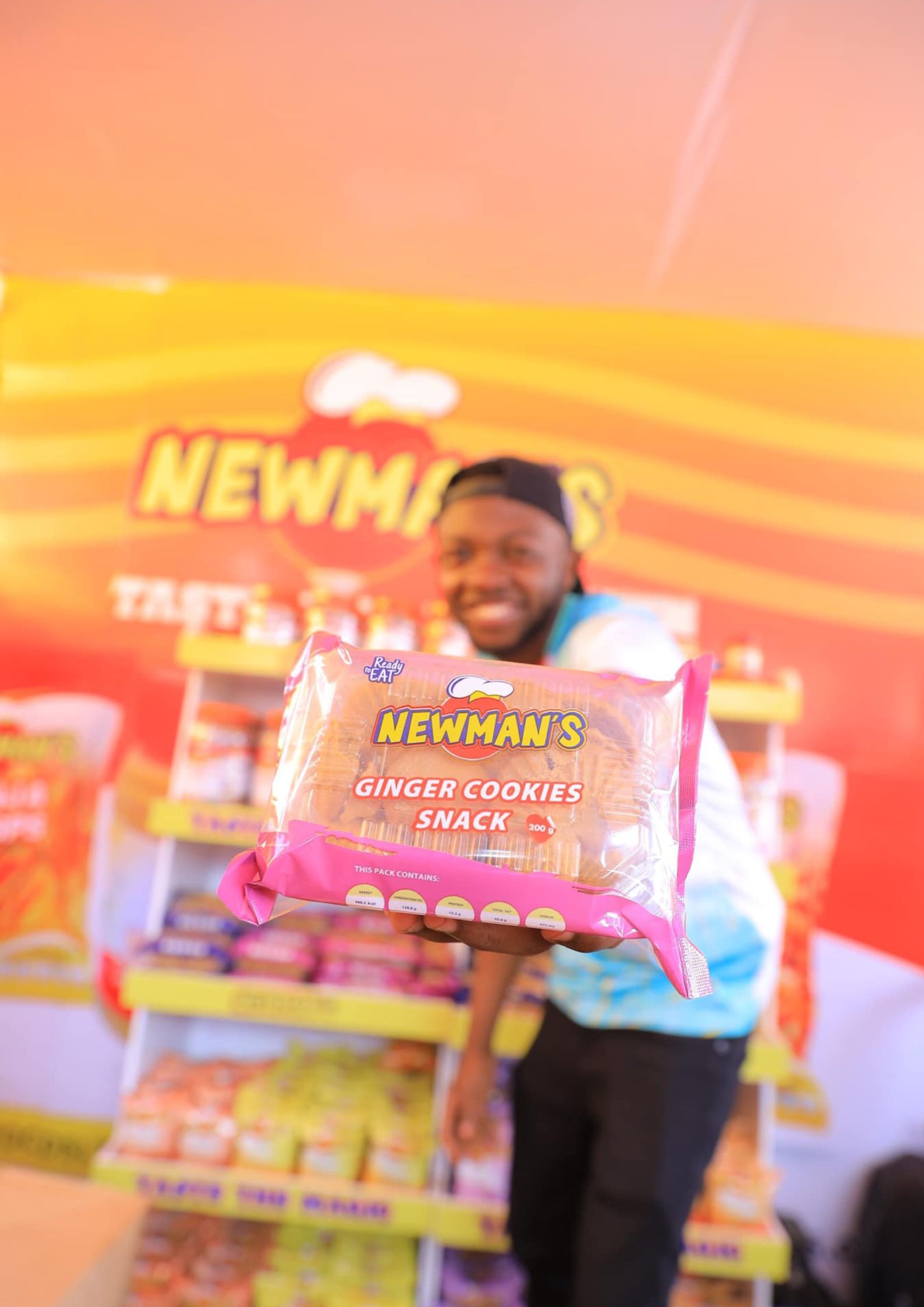 A man in cap holding up Newman's Ginger Cookies