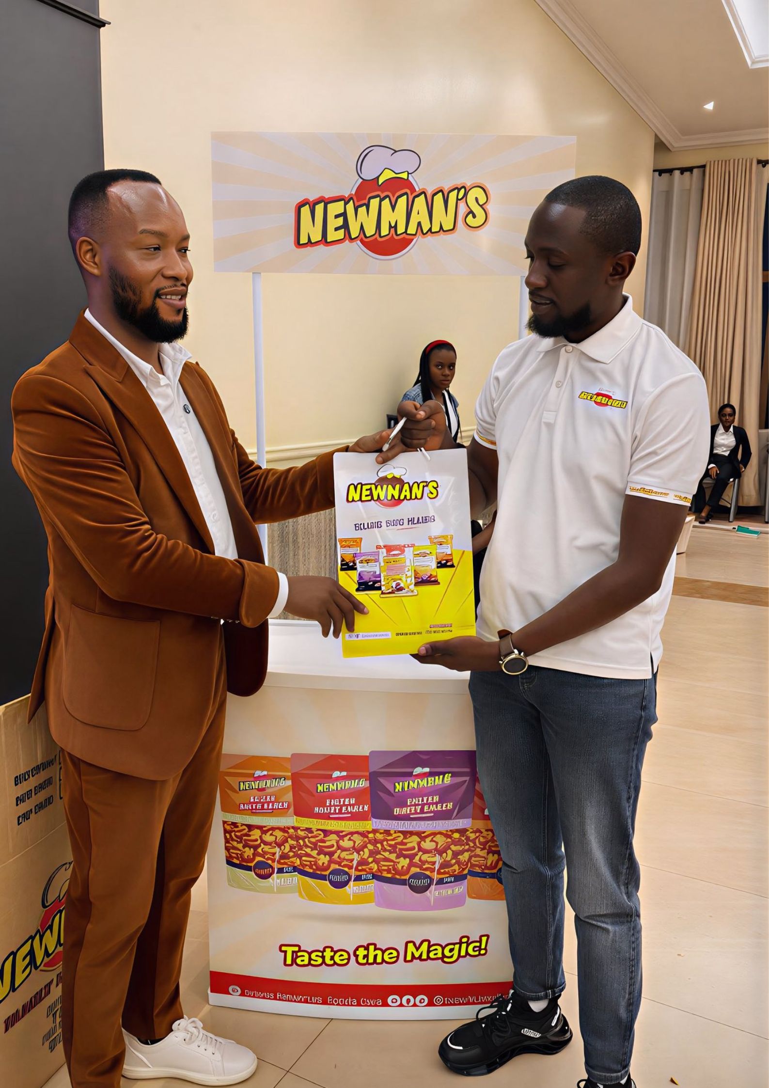 A Newman;s representative handing over a Newman's bag to a man dressed in a brown suit at the KAMOSA Annual Dinner 2025